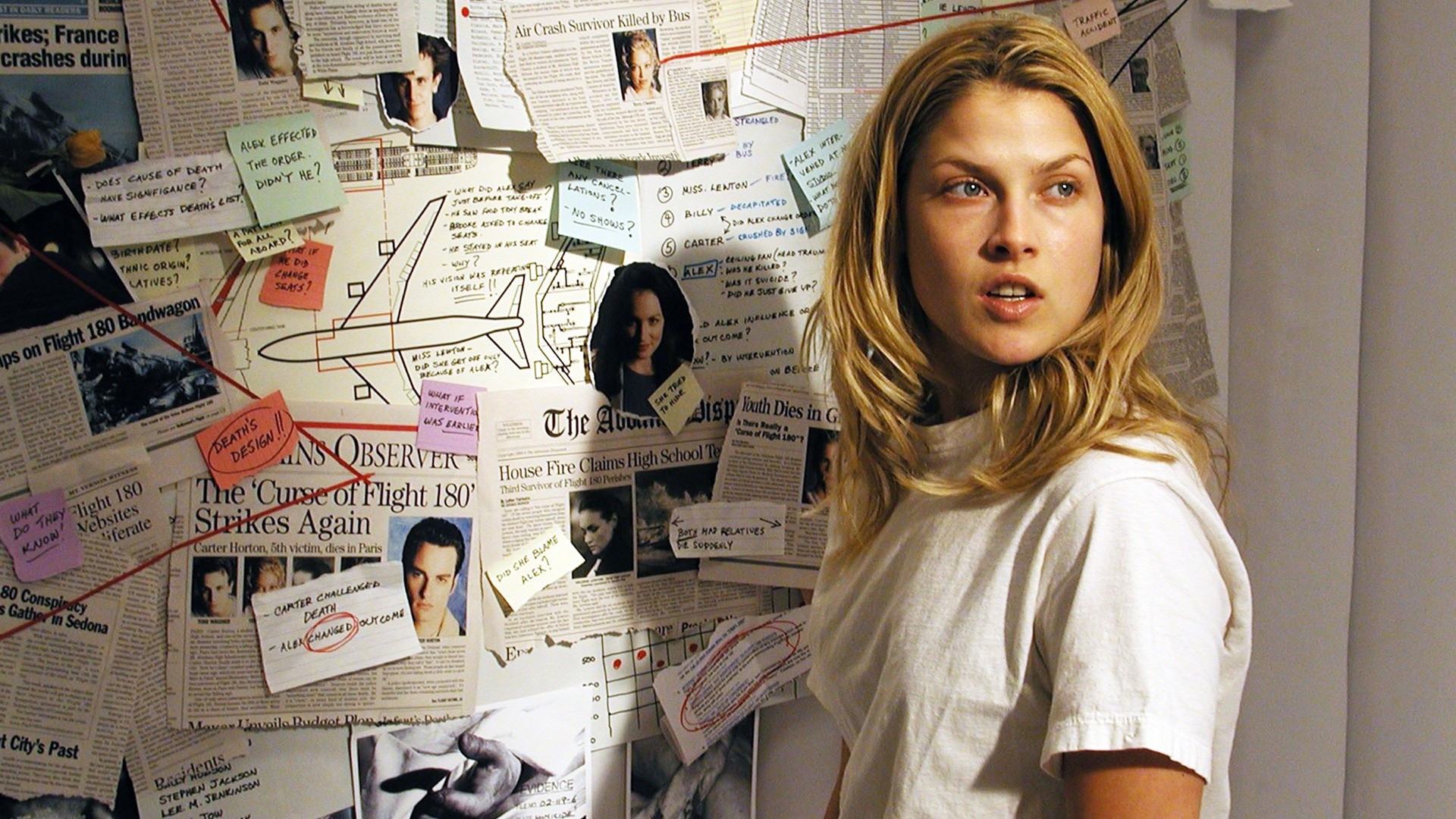 Clear beside a wall of Flight 180 clippings and notes.