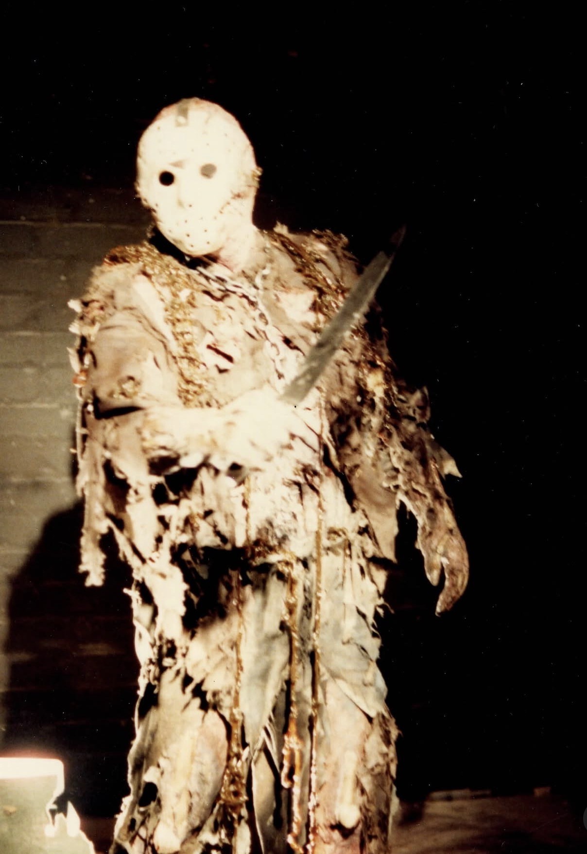 Jason costume test: masked machete pose.