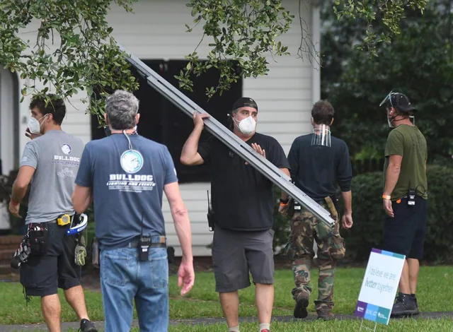Crew carrying lighting equipment.