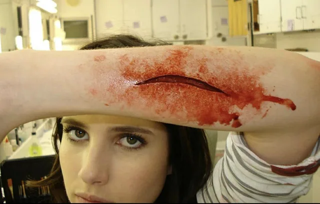 Emma Roberts displays a prosthetic wound.