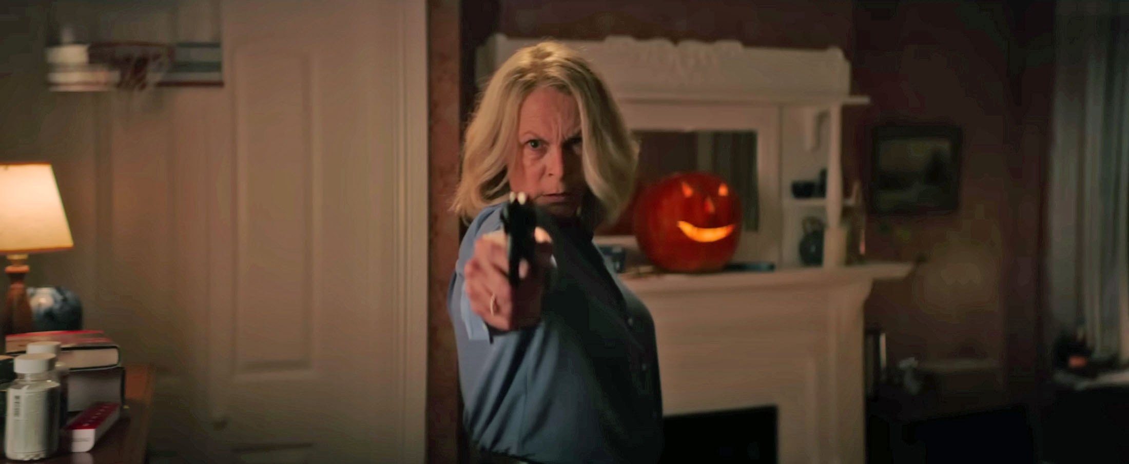 Laurie aims a pistol in the living room, from an official promotional frame.