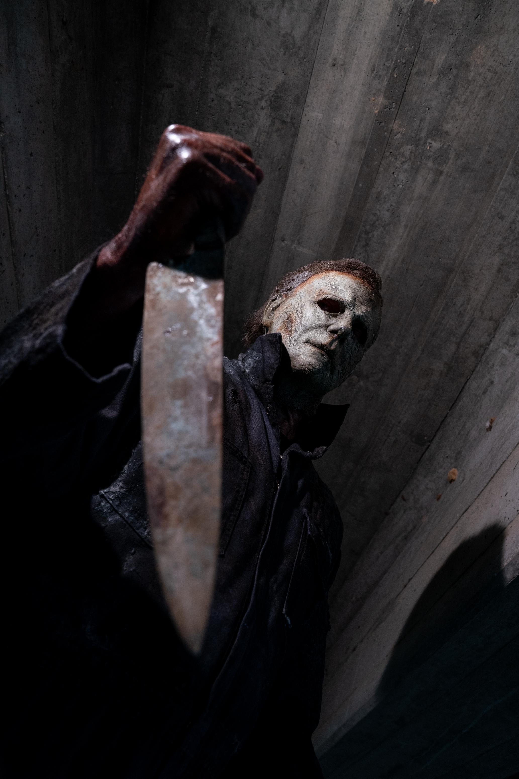 The Shape raises a cleaver from a low-angle viewpoint.