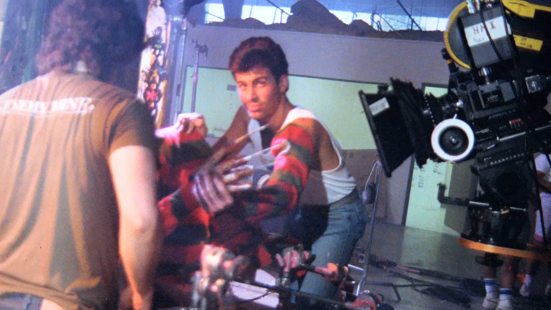 An effects performer sits beside the camera while wearing a Freddy sweater.