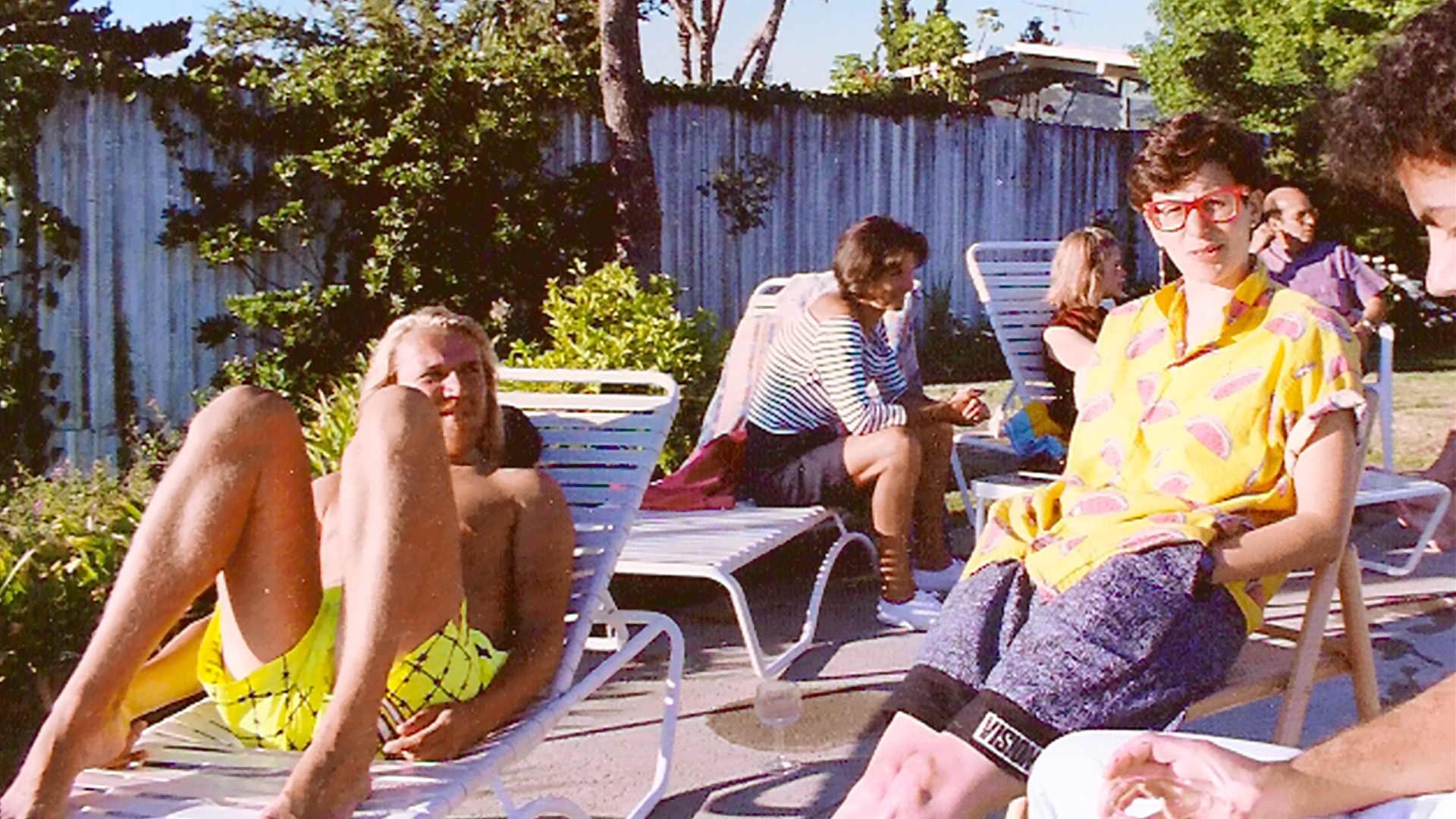 Cast members resting beside the swimming pool location.