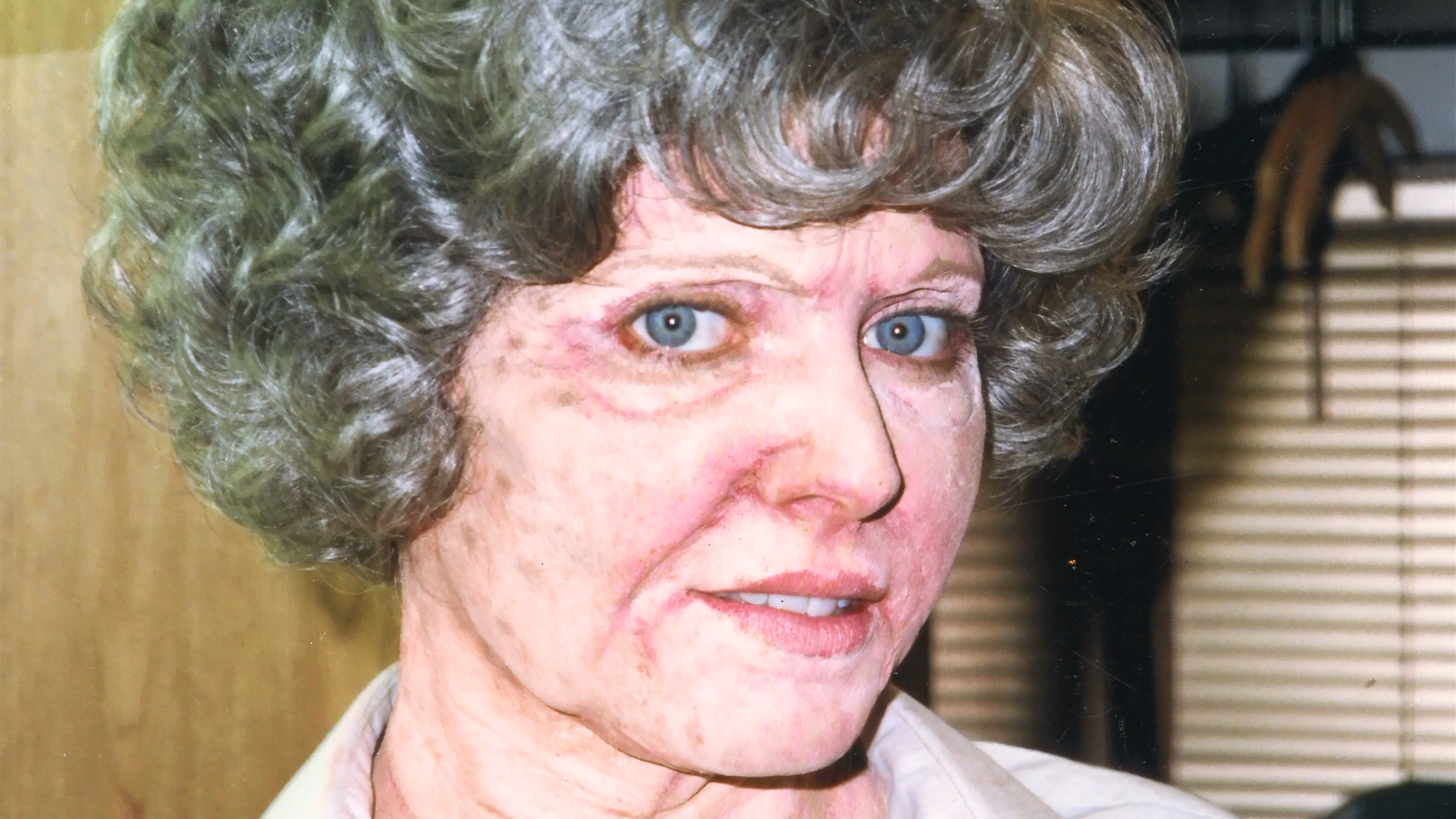 A close reference photograph of the completed aged-Alice makeup and gray wig.