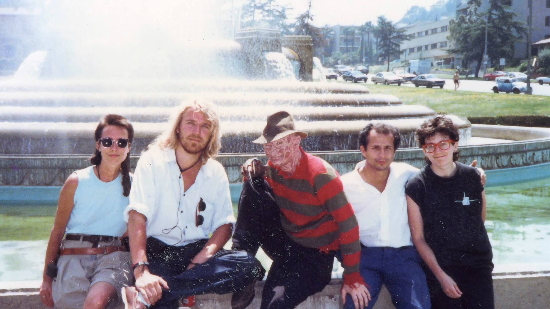 Renny Harlin, Freddy and companions posed at an outdoor fountain during film publicity.