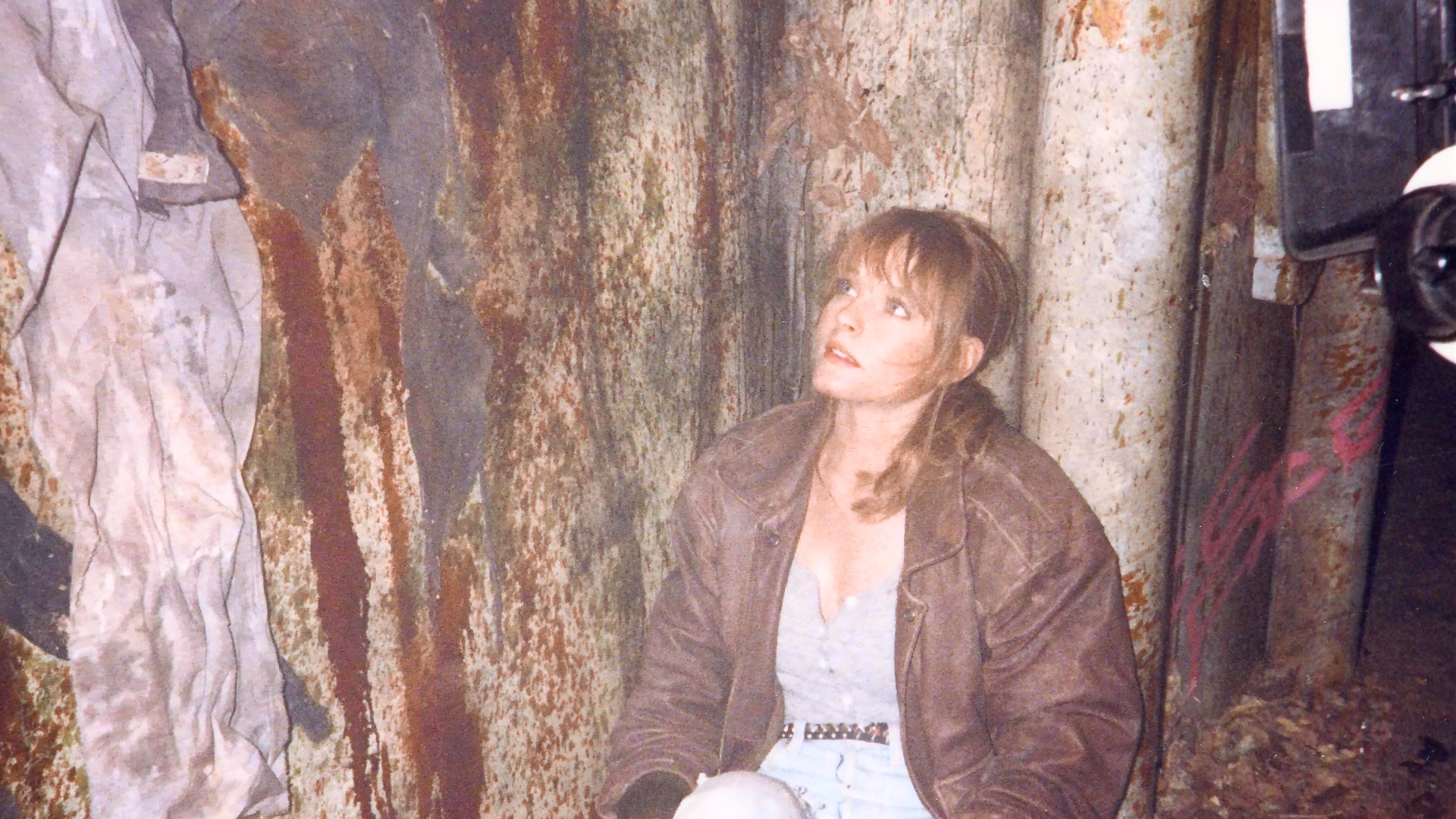 Alice looking upward in the ruined boiler-room setting.