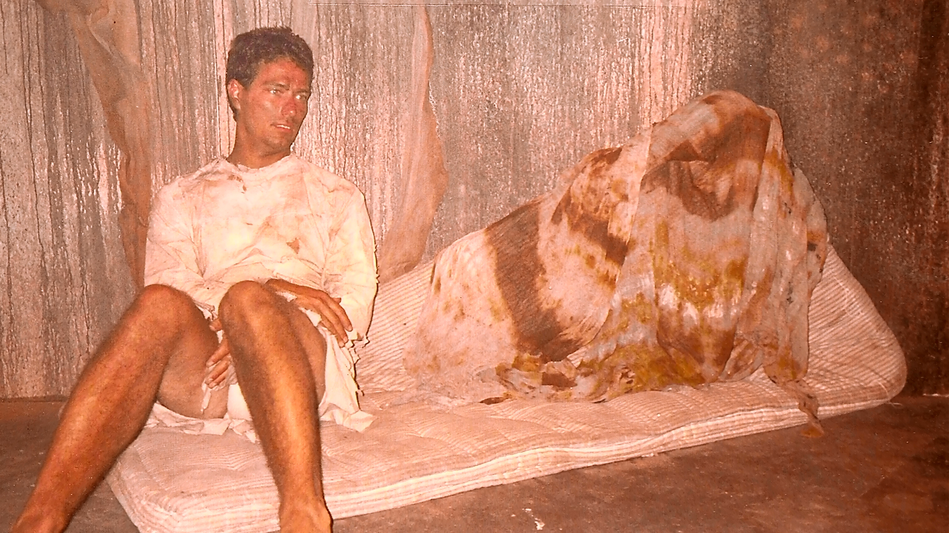 Kelly Jo Minter resting on the covered bed or tub set between takes.
