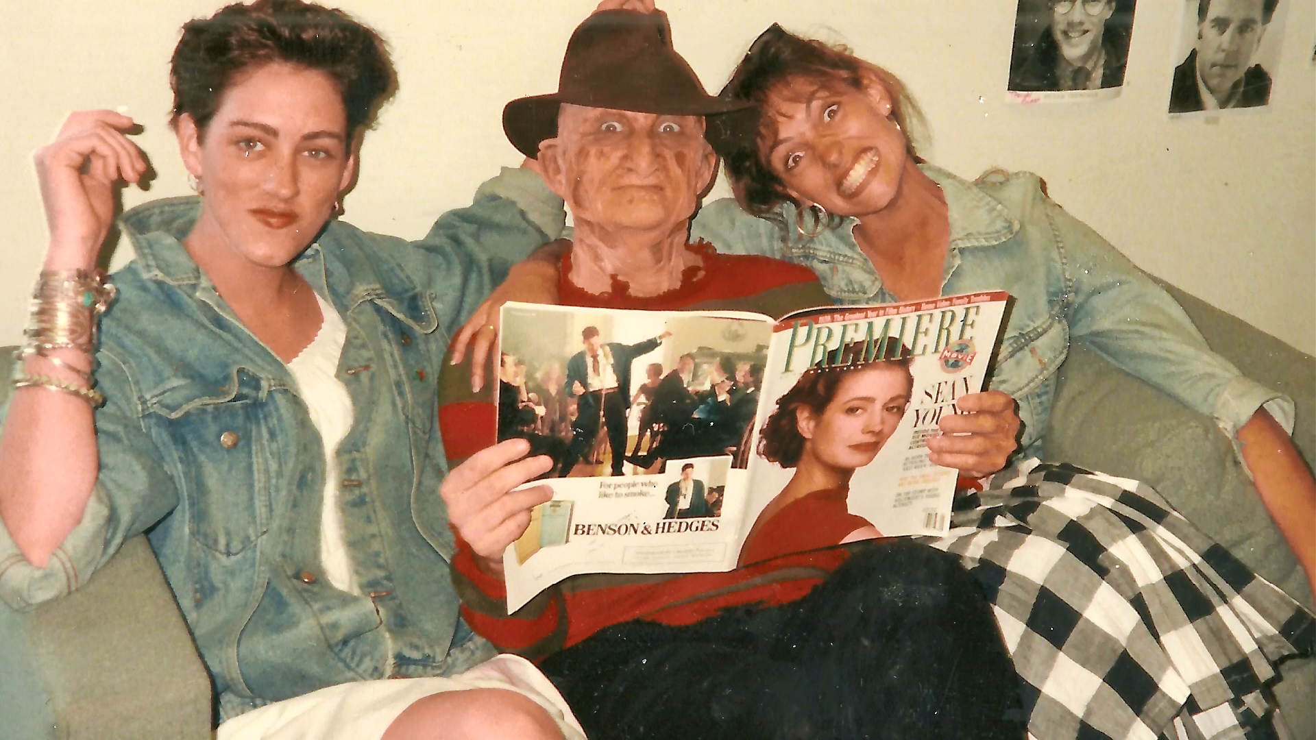 Robert Englund in makeup with two companions and a magazine between setups.