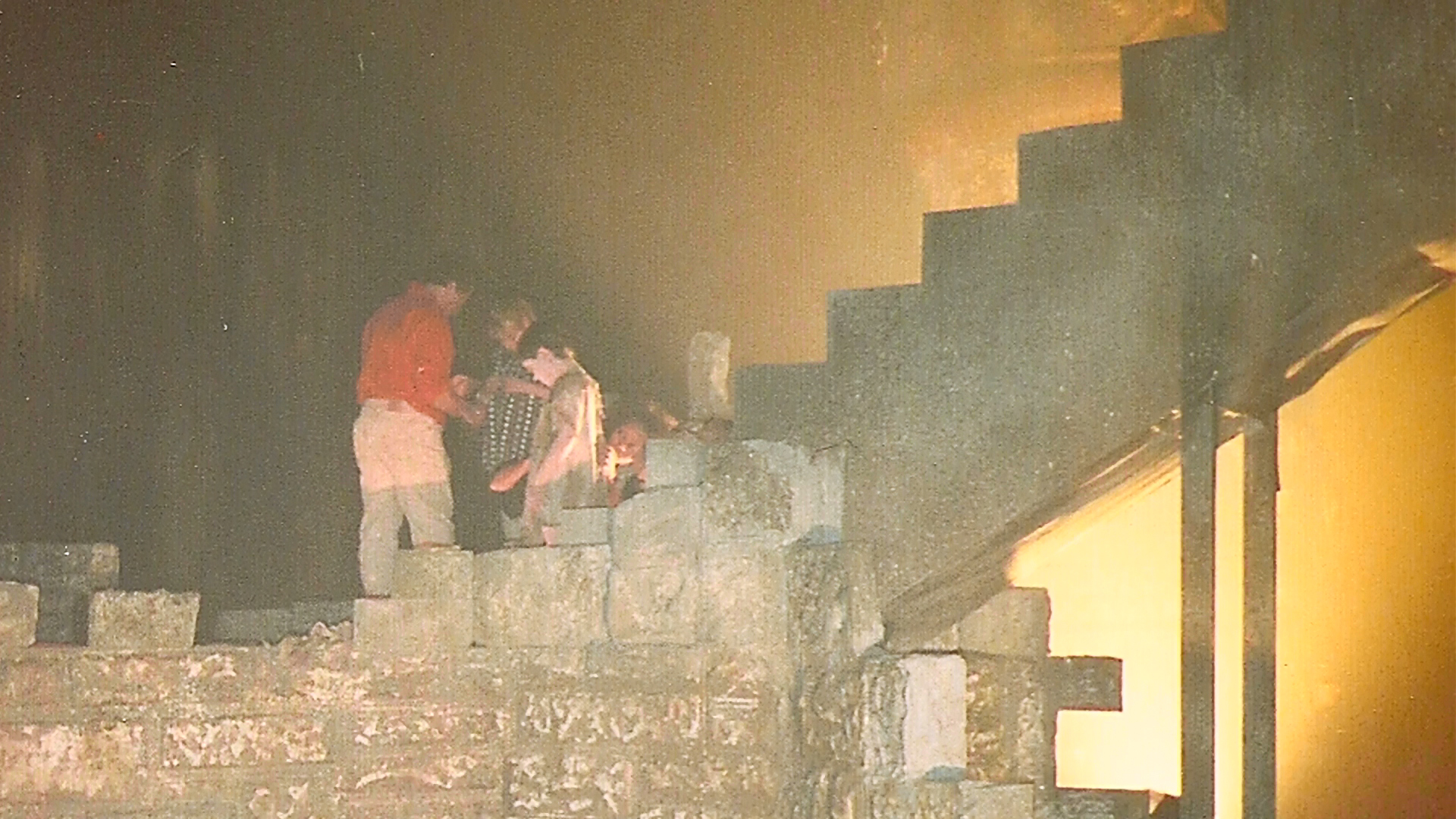 Crew members working halfway up the staircase set.