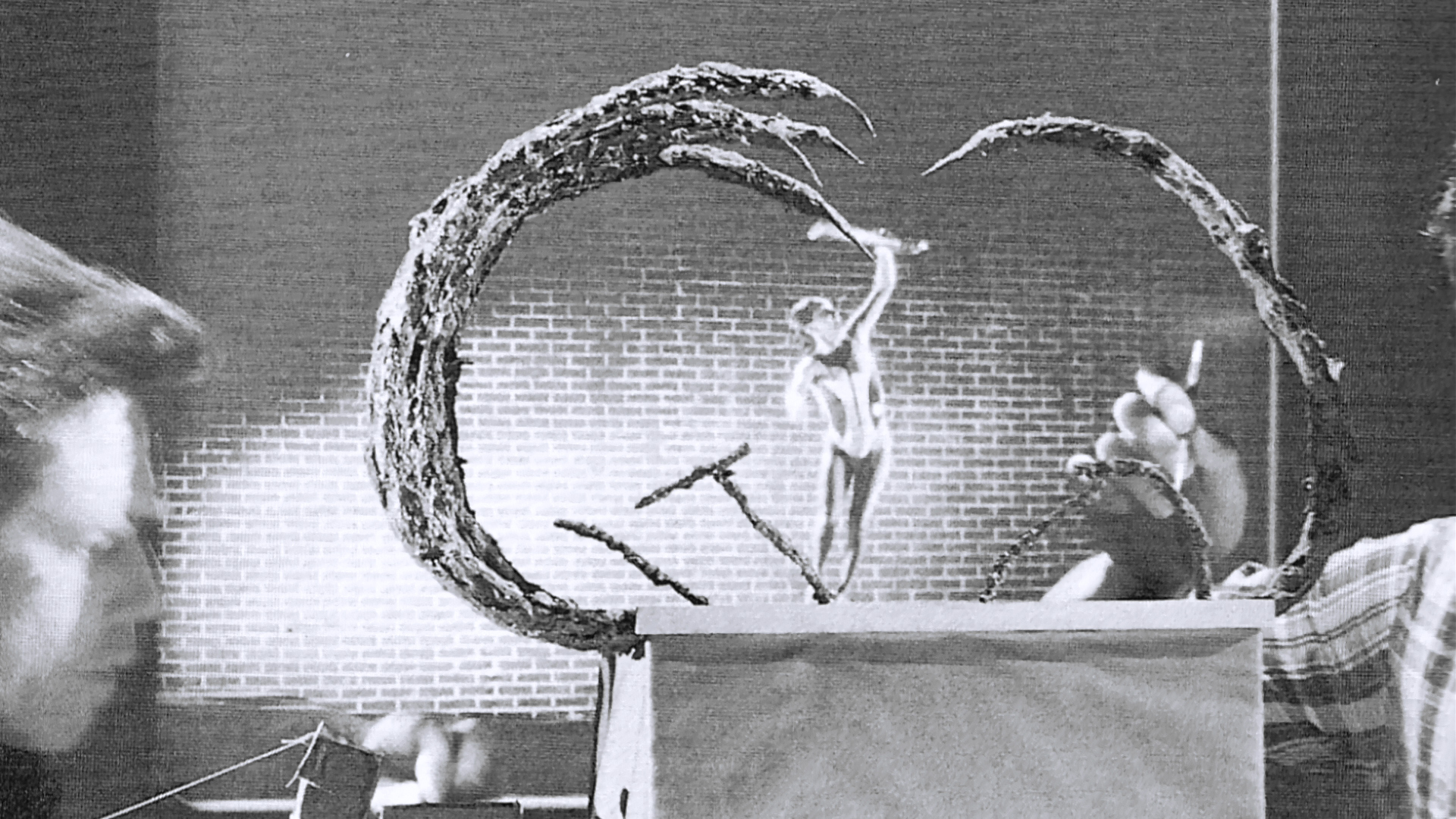 Artists hold the miniature creature-and-tendril effects rig in the workshop.