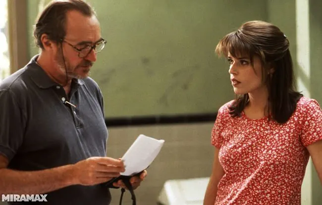 Wes Craven and Neve Campbell review a script on the school-bathroom set.