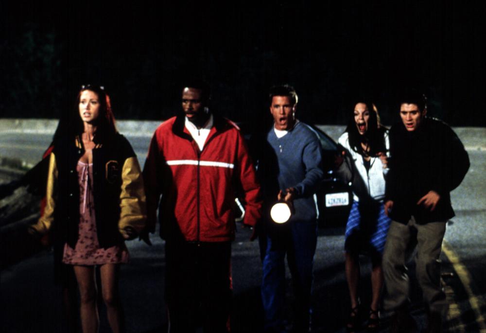 Friends search the road with flashlights.