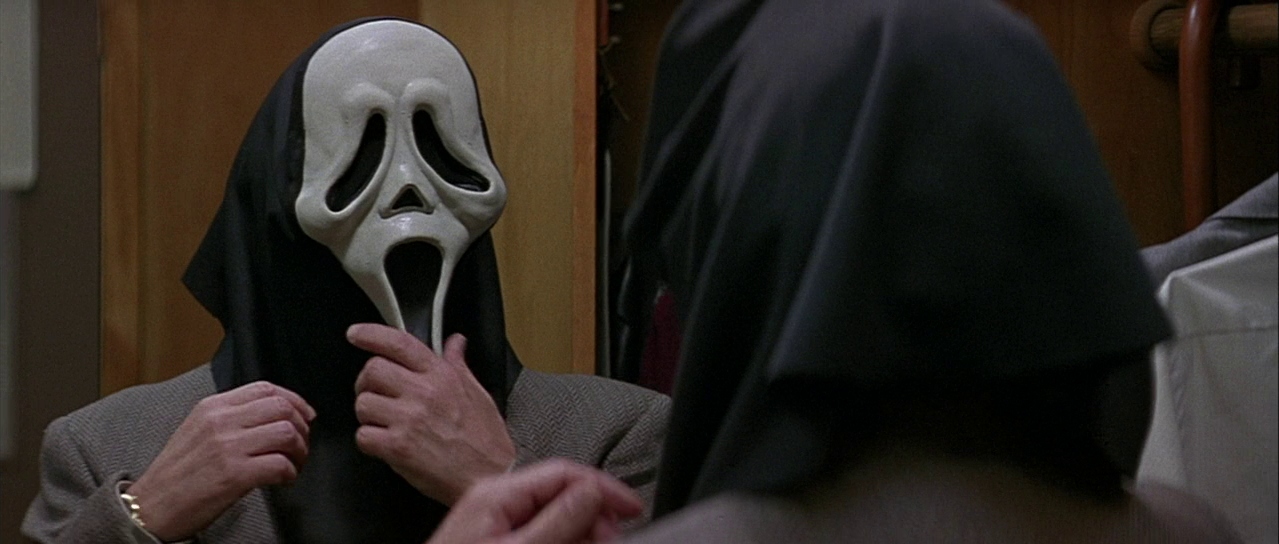 Principal Himbry wearing a Ghostface mask. Film frame.