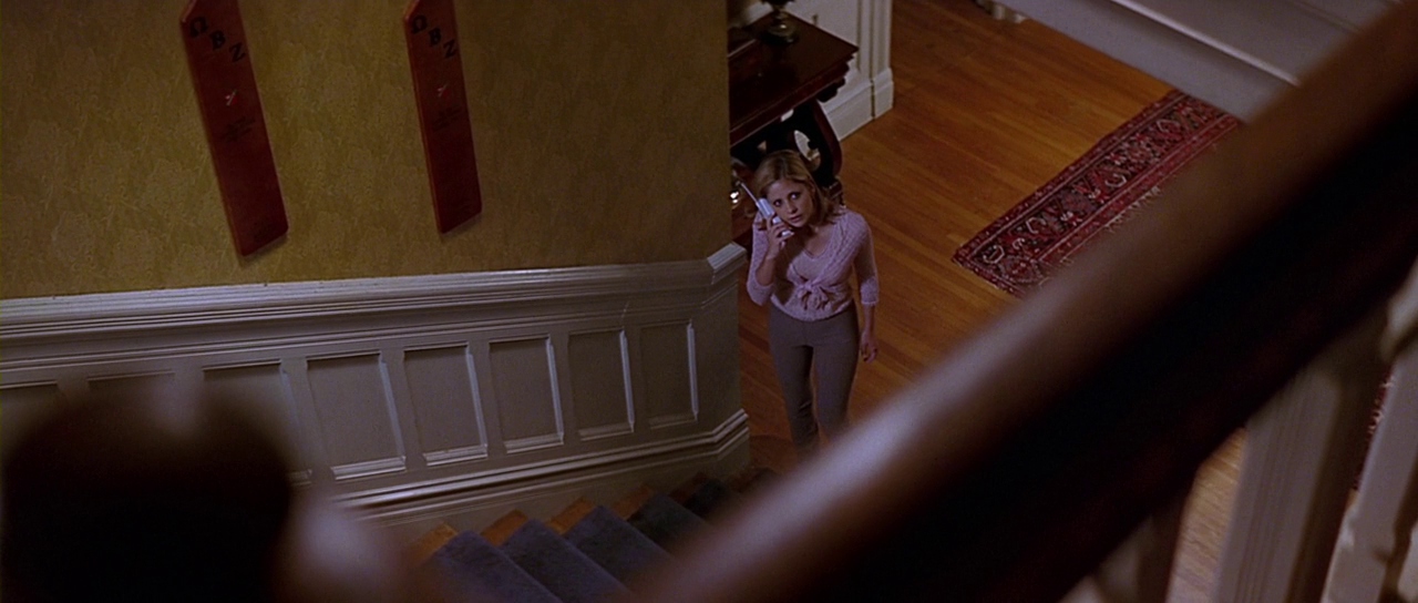 Cici viewed from above the staircase. Film frame.