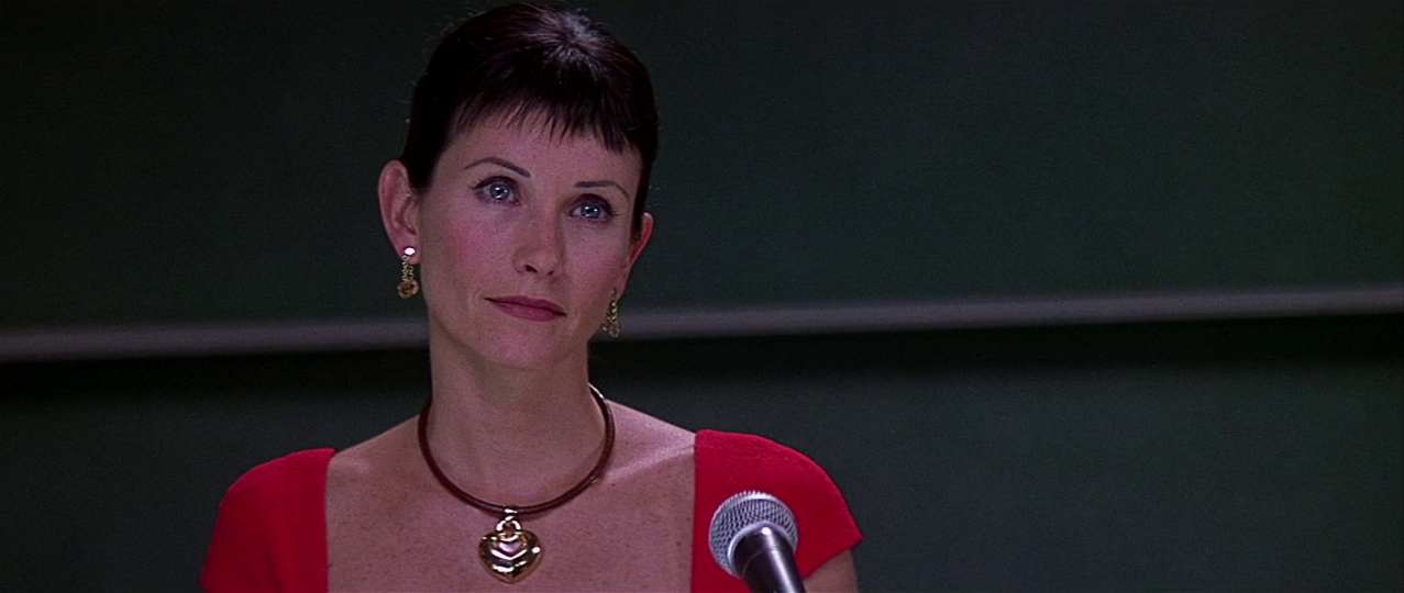 Gale speaking at a lectern. Film frame.