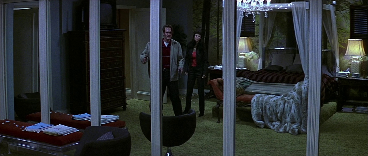 Dewey and Gale beside mirrored doors. Film frame.