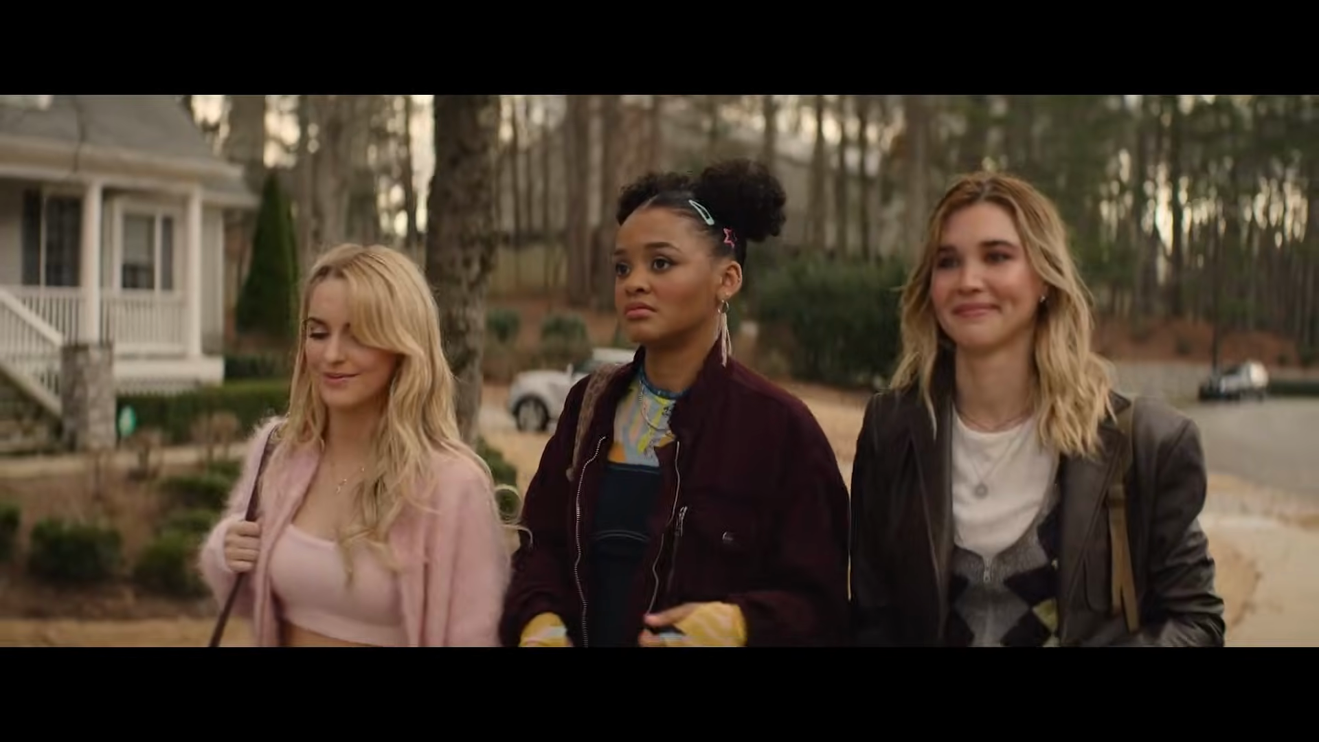 Three friends walk together through the neighborhood.